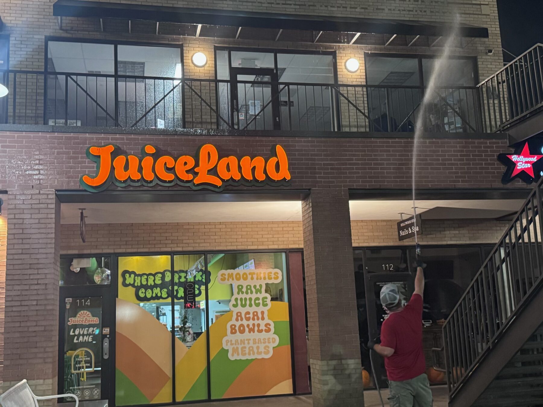 High-reach wash on a commercial storefront at night